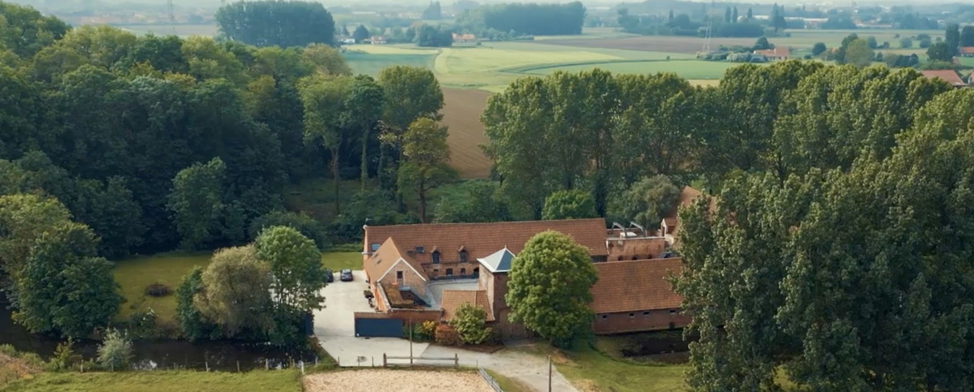Vue aérienne du domaine entouré d'arbres et de prairies